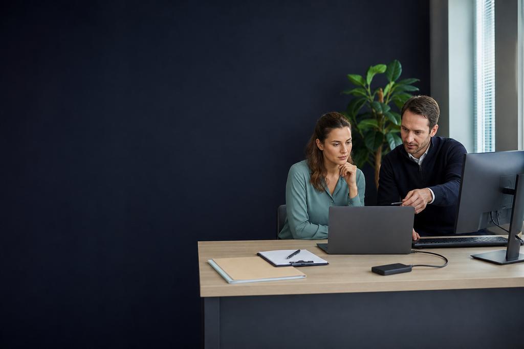 Bestanden beheren in beeld: een Microsoft 365-specialist en medewerker die teamdocumenten, OneDrive-synchronisatie, offline gebruik en versieherstel testen